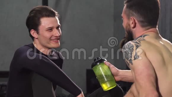 年轻的男运动员在健身房和他的朋友聊天视频的预览图