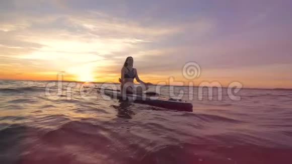 一位年轻女子坐在船上欣赏日落美景视频的预览图