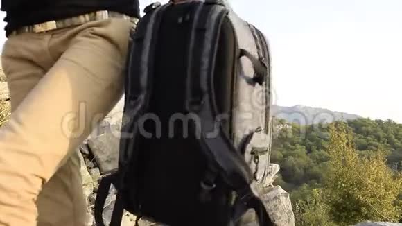 作物观的一名女子背着背包走在山崖上迎着美丽的山峰视频的预览图
