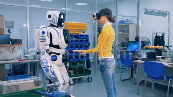 机器人类人正把手放在一个年轻女人的手上视频的预览图