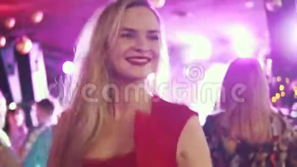一个女孩在聚会上跳舞的肖像音乐会上穿红裙子的年轻女子视频的预览图