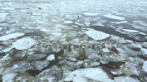 冬季或春季的河流冰流降雪鸟瞰视频的预览图