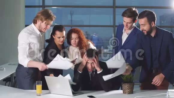商人工作压力很大同事们在他脸上摇晃着文件视频的预览图