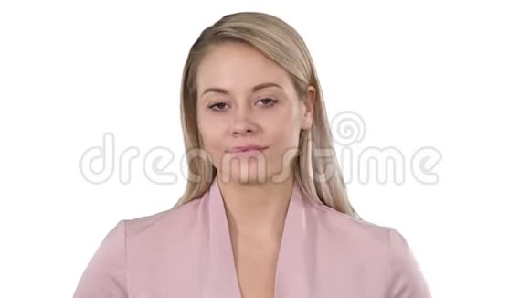 年轻漂亮的女士穿着粉红色的衣服看着相机想着白色背景上微微微笑的东西视频的预览图