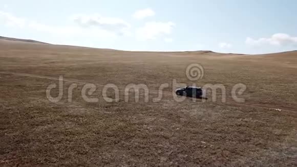 空中镜头拍摄与无人驾驶皮卡骑在西伯利亚草原视频的预览图