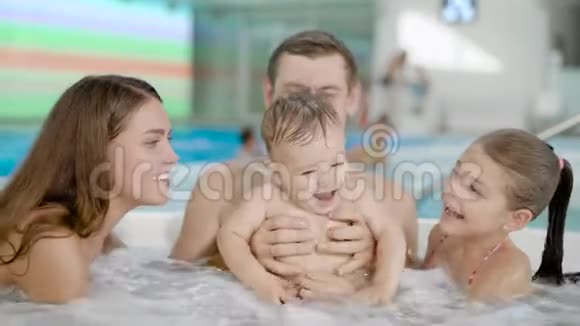幸福的家庭坐在按摩浴缸里视频的预览图