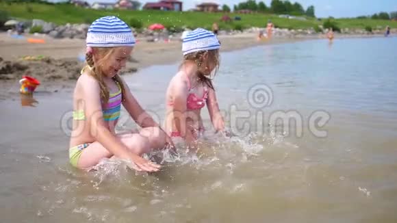 两个小女孩在海滩上倒水幼儿玩笑创编泼水海上暑假视频的预览图