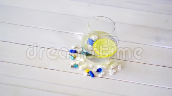 一杯柠檬水晶水和一套白色木桌上的药片视频的预览图