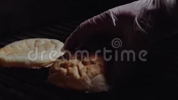 厨师准备汉堡在烤架上煎面包厨师在烤架上把面包变成汉堡视频的预览图