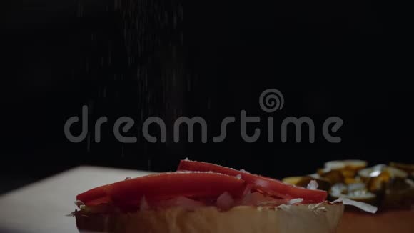 厨师准备汉堡在烤架上煎面包加入胡椒粉视频的预览图