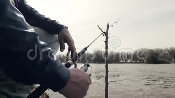 渔人手在钓鱼时用鱼竿旋转钓竿视频的预览图