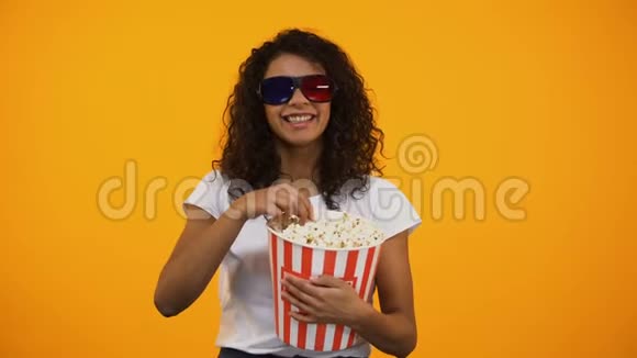 戴3D眼镜的黑女人吃爆米花看喜剧电影休闲视频的预览图