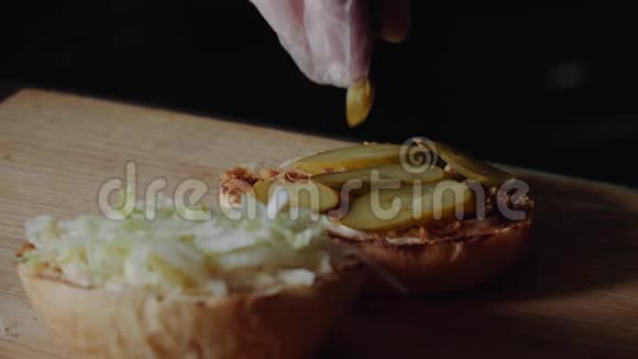 煮大汉堡的过程是专业厨师特写在面包上放奶酪馅饼视频的预览图