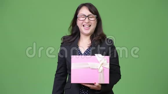 成熟美丽的亚洲女商人手捧礼盒竖起大拇指视频的预览图