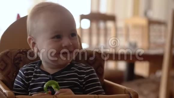 小宝宝坐在婴儿椅上吃食物视频的预览图