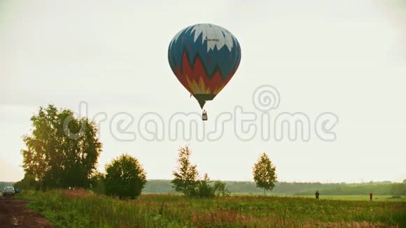 利用高温技术在草地上飞行的彩色气球日落视频的预览图