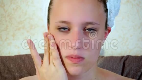 少女把润肤霜涂在脸上她照顾皮肤特写视频的预览图