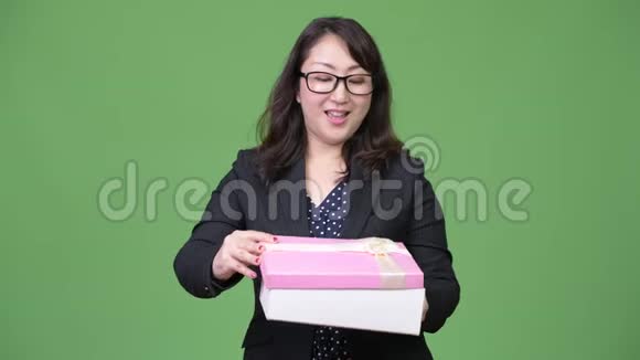 成熟美丽的亚洲女商人打开礼品盒时显得惊讶视频的预览图