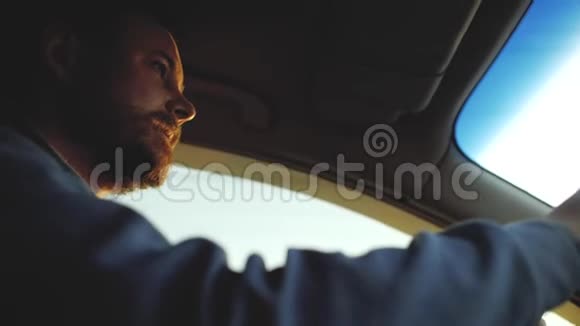 一个长着漂亮眼睛的胡子的人在开车窗外的阳光视频的预览图