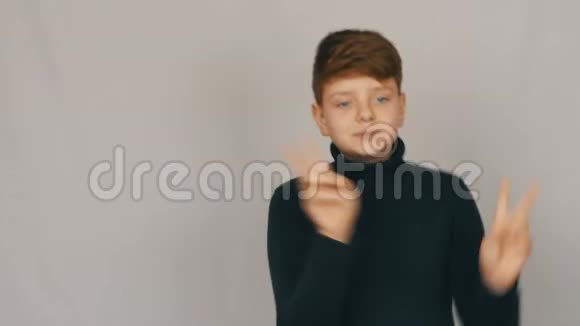 一个有趣的红头发和蓝眼睛的少年男孩的肖像在白色背景下在镜头前滑稽有趣地跳舞视频的预览图
