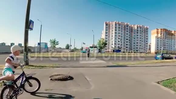 男孩骑着一辆儿童自行车在人行横道上穿过街道视频的预览图