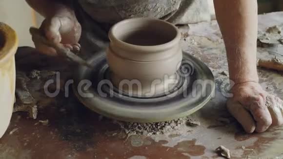 男用手在旋转锅具上用刀装饰陶瓷锅抛盘做装饰品视频的预览图