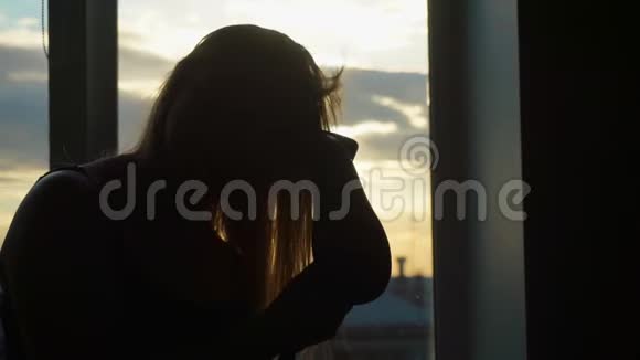 一位中年妇女在日落时分烘干吹风机她唱歌跳舞视频的预览图