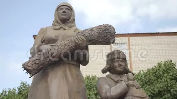 二战期间在俄罗斯村庄公园的后方工人雕塑母亲和儿子视频的预览图