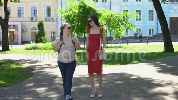 胖瘦的女性朋友在公园散步聊天身体对比饮食视频的预览图