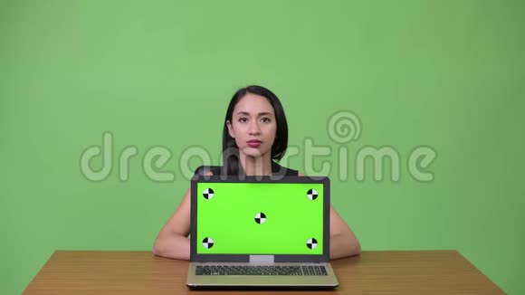 年轻漂亮的亚洲女商人带着年轻人路过的手提电脑视频的预览图