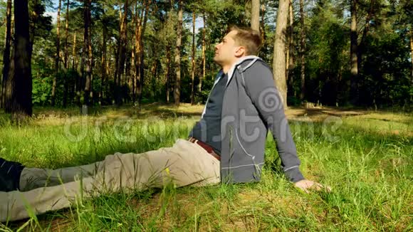 夏天公园或森林里坐在草地上的年轻人放松点视频的预览图