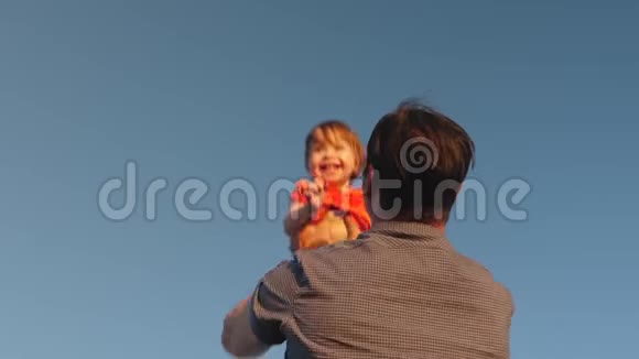 爸爸和一个小孩子玩爸爸把女儿抛在蓝天上幸福的家庭在晚上和视频的预览图