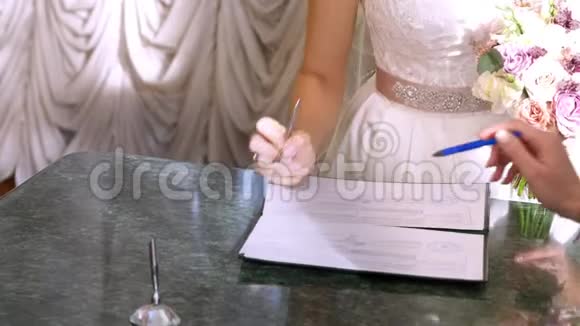 婚礼传统仪式结婚典礼新婚夫妇签署结婚文件结婚证特写镜头视频的预览图
