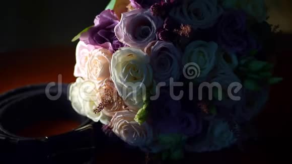 特写美丽的婚礼花束玫瑰乳制品白色和丁香在黑暗中玩光和阴影视频的预览图