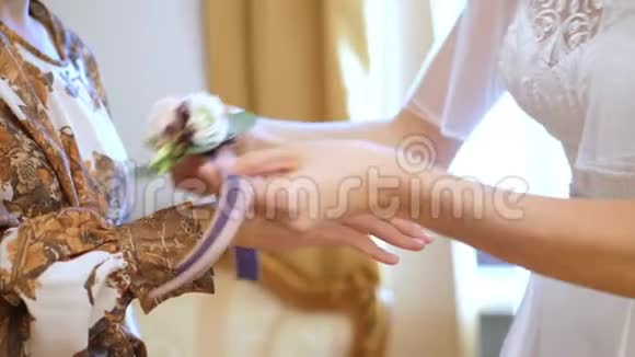 新娘费用为婚礼做准备新娘正在把一朵花绑在她身上视频的预览图