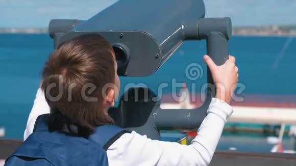 无法辨认的男孩透过望远镜看海视频的预览图