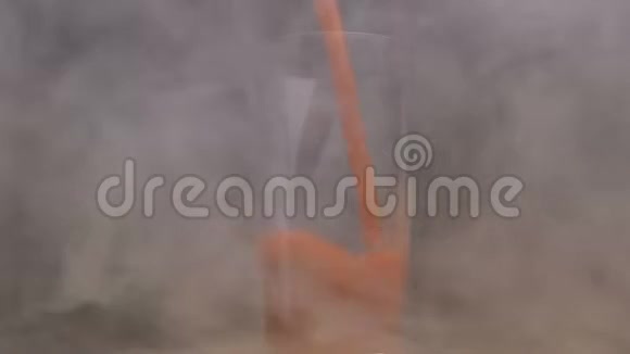 在烟雾中将100种天然番茄汁倒入旋转玻璃中视频的预览图