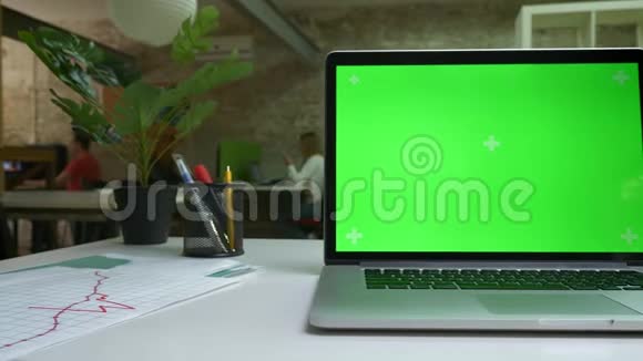 带有绿色屏幕特写的电脑在白色的桌子上办公环境工作心情空间空旷视频的预览图