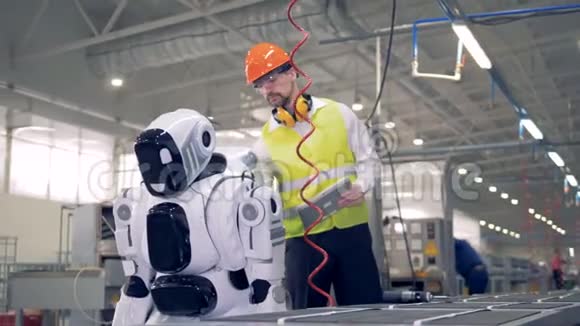工厂的男员工正在更换一个机器人然后它就开始打钻视频的预览图