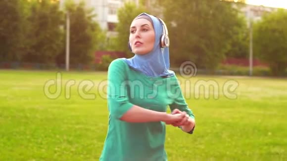 穿着头巾的漂亮的穆斯林女孩温暖起来视频的预览图