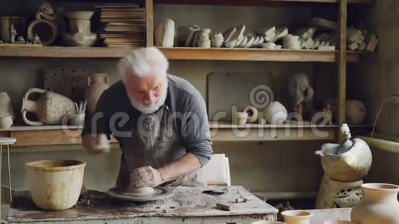 创意工匠正在陶工的车轮上用粘土制作小陶瓷碗手工粘土制品专业视频的预览图