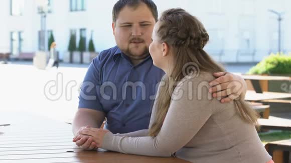 一对肥胖的年轻夫妇说着牵手在一起计划生育视频的预览图