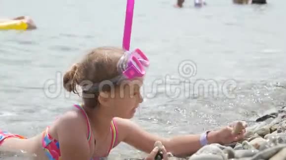 美丽的小女孩在海上玩耍可爱的微笑着戴着口罩和呼吸器管游泳4K视频的预览图