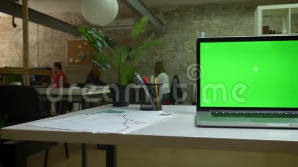 在桌子上拍摄笔记本电脑绿色屏幕显示办公室现代化房间室内视频的预览图