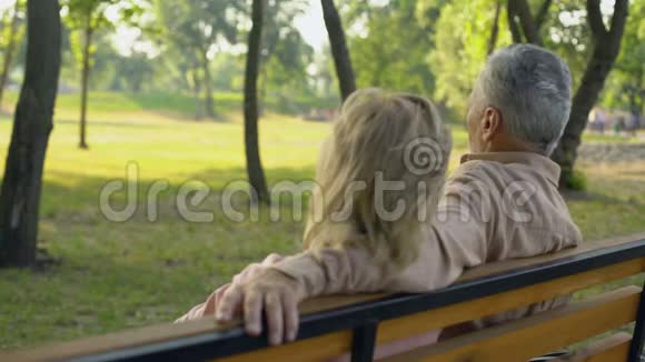老两口坐在长凳上远远地看着旅游景点旅行视频的预览图