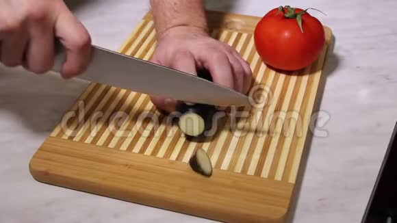 男人手在厨房的木板上劈茄子视频的预览图