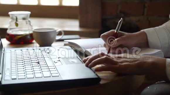 妇女在笔记本上记笔记和使用笔记本电脑视频的预览图