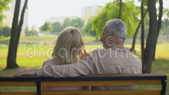 快乐的夫妻坐在公园里拥抱计划旅行相互理解视频的预览图
