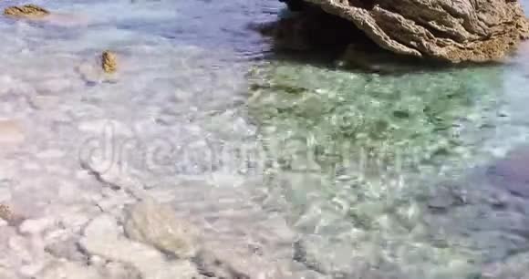 小浪在岩石海岸上翻滚视频的预览图
