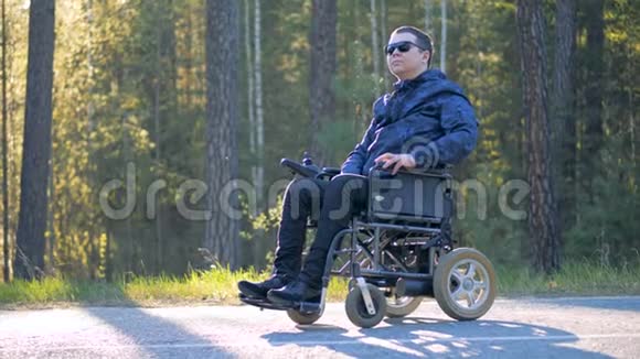 一个坐轮椅的人在森林里环顾四周视频的预览图
